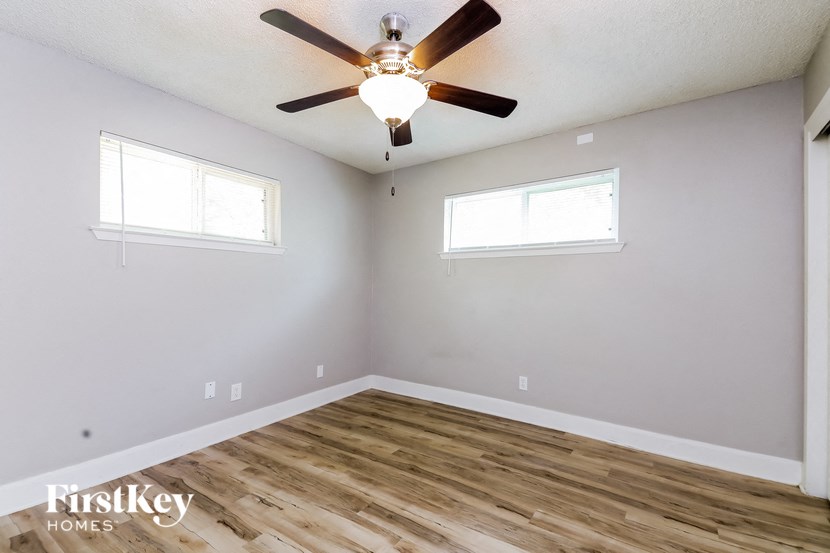 the living room has a ceiling fan and wood flooring