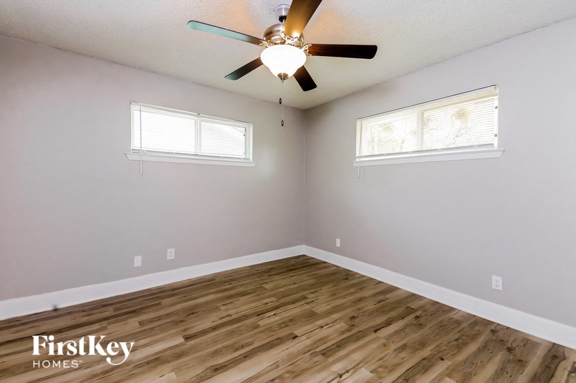 the living room with wood floors and a ceiling fan
