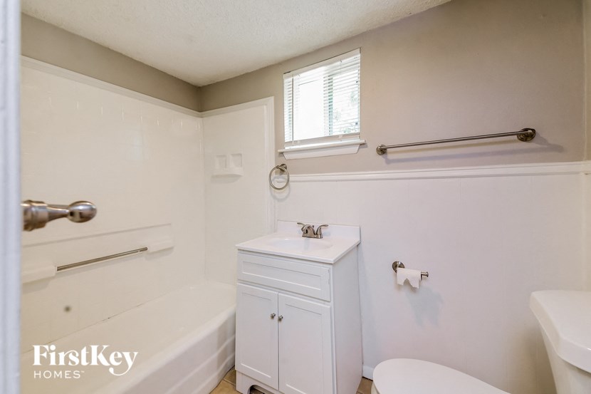 a white bathroom with a tub sink and toilet