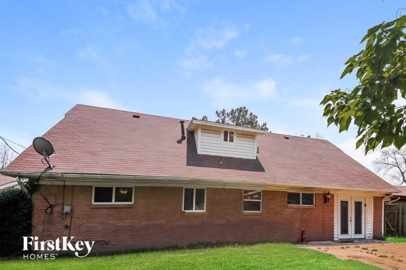 a red brick house with a red roof and a satellite dish