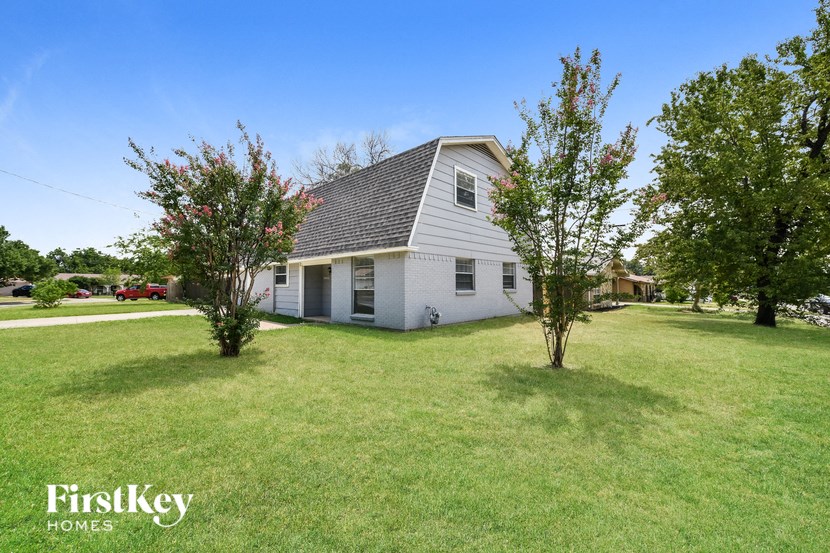 a white house with a yard and some trees
