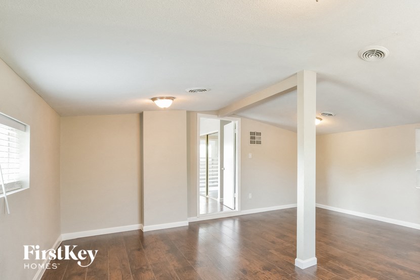 an empty living room with white walls and wood floors