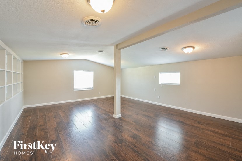 an empty living room with wood floors and white walls