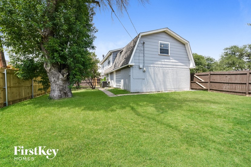 a house with a yard and a tree in front of it