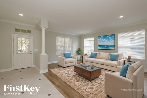 A living room with a couch, a coffee table, and a painting on the wall.