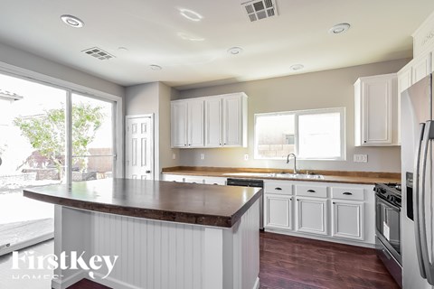 A kitchen with white cabinets and a brown countertop.