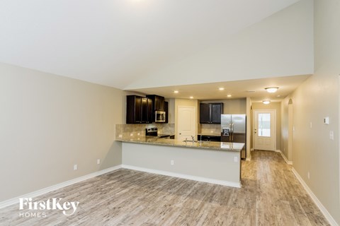 A spacious kitchen with wood flooring and a white countertop.