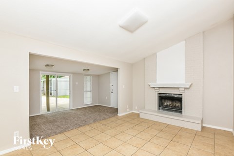 A spacious living room with a fireplace and a skylight.