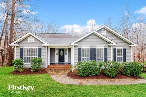 a home with blue siding and a front yard with green grass