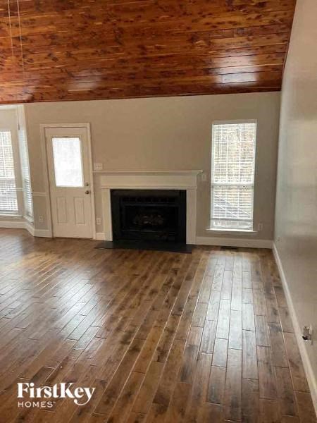 a living room with a wood floor and a fireplace