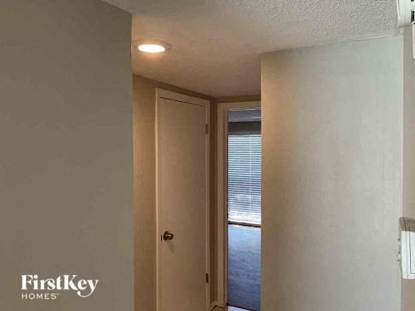 A hallway with a door leading to a window.