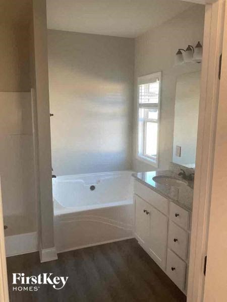 a white bathroom with a tub and a sink
