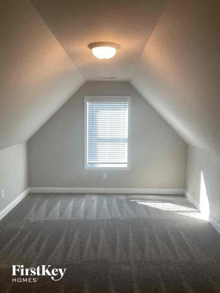 an empty attic with a window and a ceiling light