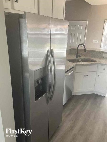 a stainless steel refrigerator in a kitchen with a sink