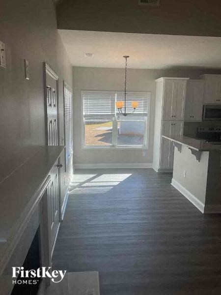 a kitchen with a wood floor and a large window