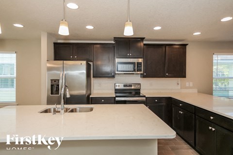 A kitchen with a white counter top and black cabinets.