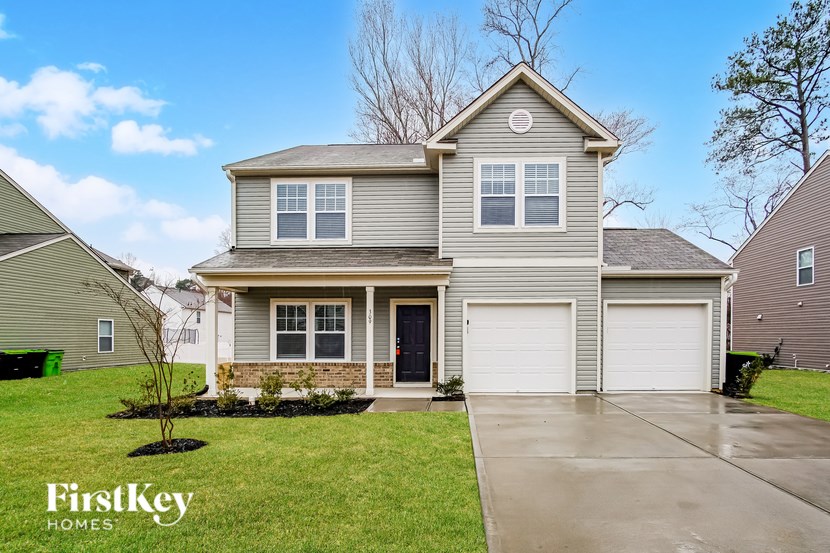 A house with a grey roof and a garage door.