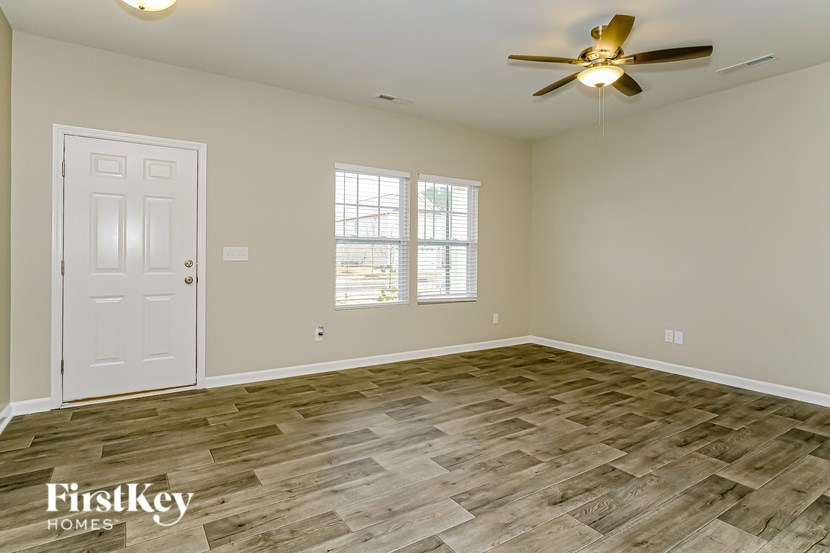 A room with a white door and a ceiling fan.