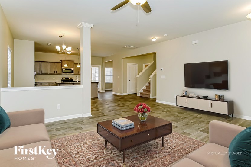 A living room with a brown coffee table and a flat screen TV mounted on the wall.