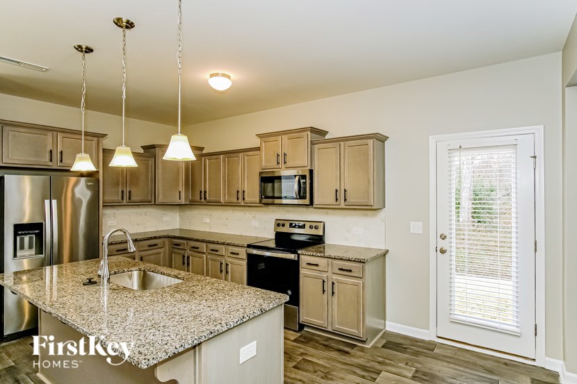 A kitchen with granite countertops and stainless steel appliances.