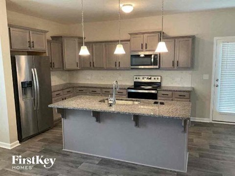 A kitchen with a granite countertop and stainless steel appliances.