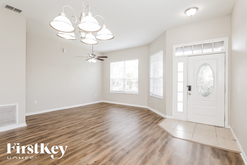 A spacious room with wooden flooring and a ceiling fan.
