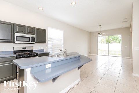 A kitchen with a blue countertop and a stove top oven.