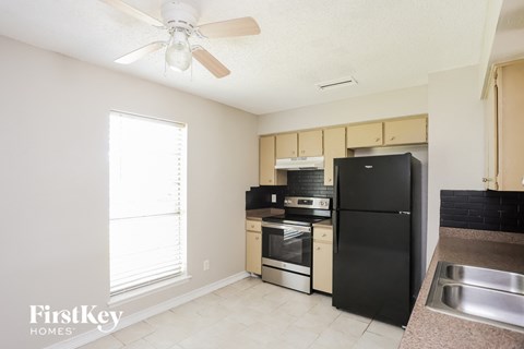 A kitchen with a black refrigerator, stove, and oven.