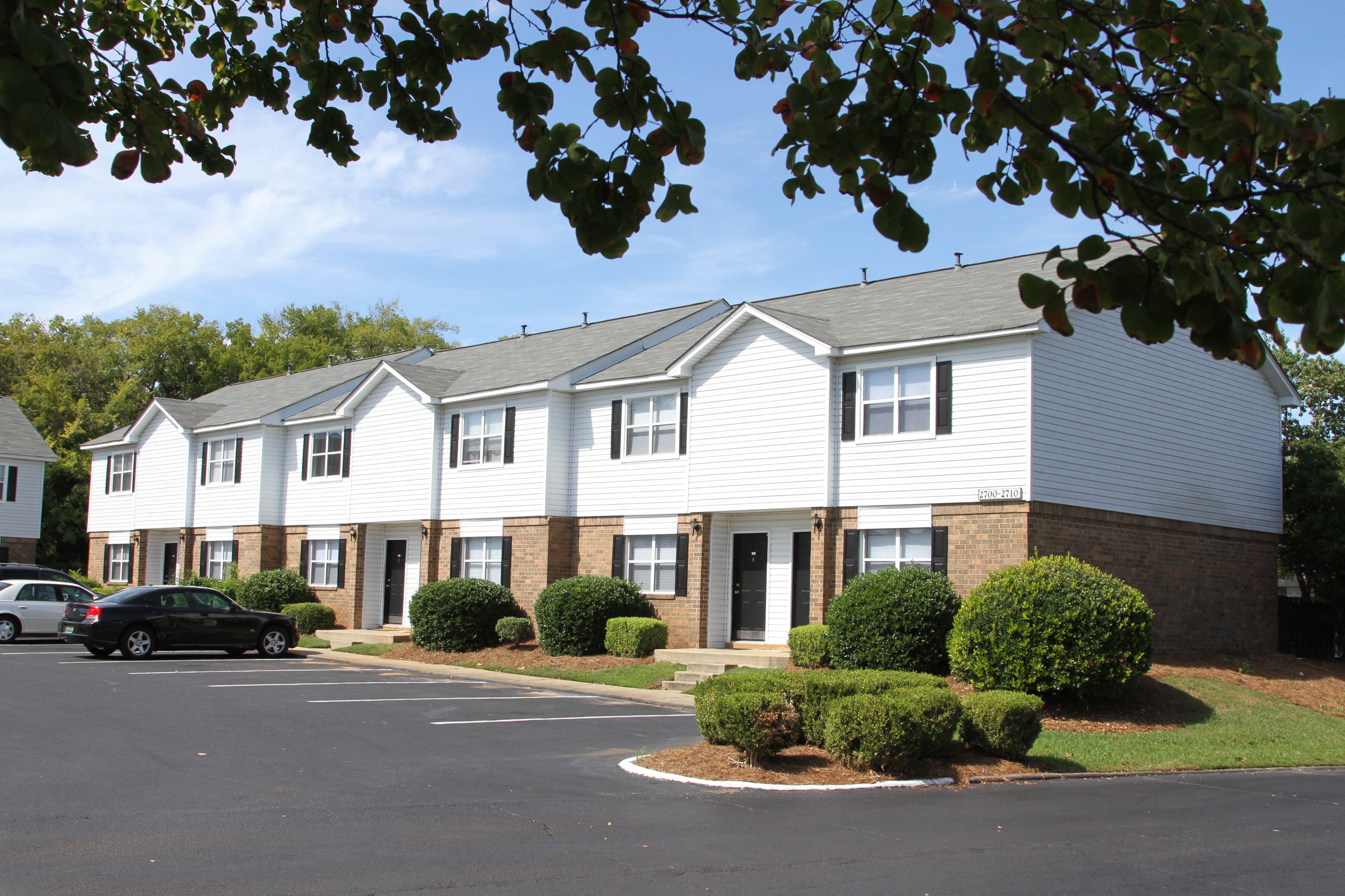 an apartment building with a parking lot and a street