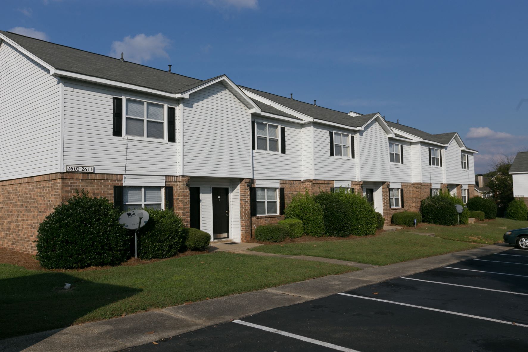 an apartment building with white siding and brick