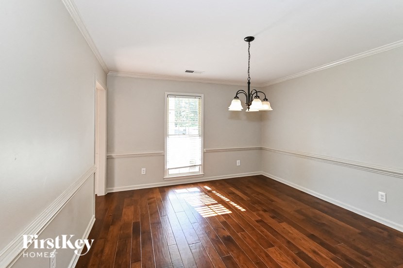 an empty living room with wood floors and a window