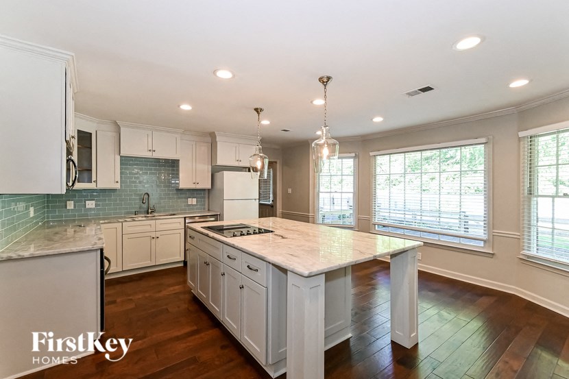 a large white kitchen with a marble counter top