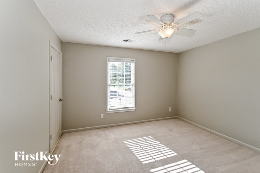 an empty room with a ceiling fan and a window