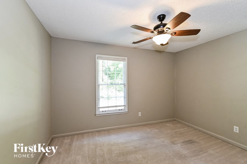 a empty room with a ceiling fan and a window