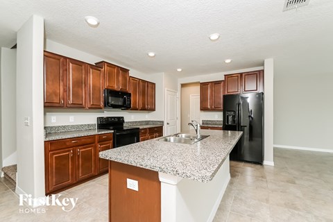 a kitchen with granite countertops and black appliances