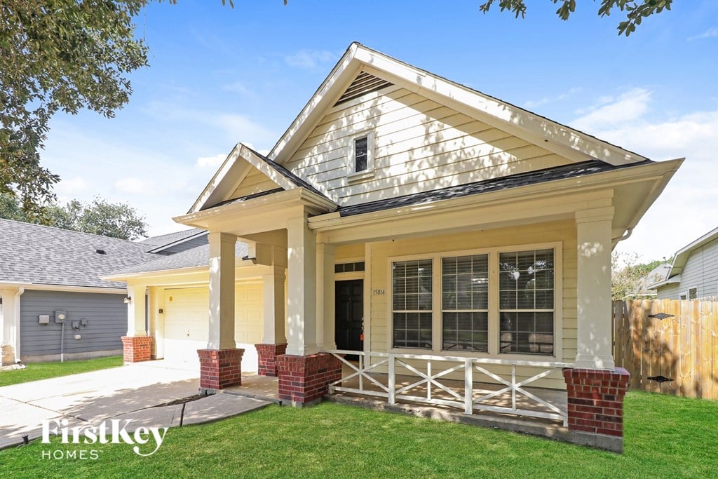 A house with a porch and a brick pillar.