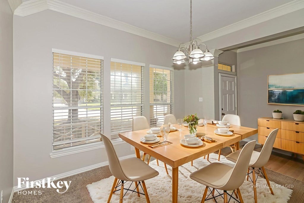 A dining room with a wooden table set for a meal.