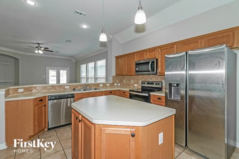 A kitchen with wooden cabinets and a stainless steel refrigerator.