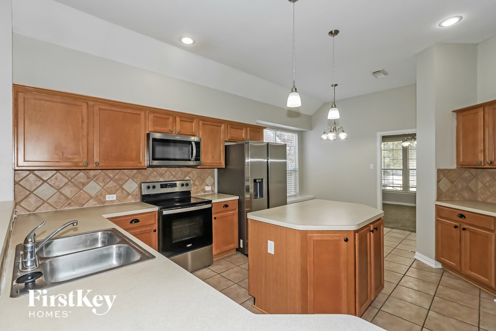 A kitchen with wooden cabinets and a stainless steel sink.
