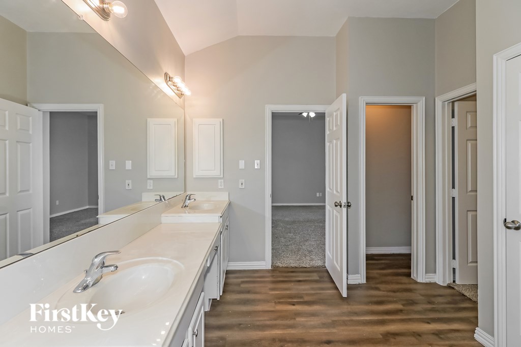 A bathroom with two sinks and a large mirror.