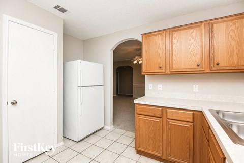 A kitchen with wooden cabinets and a white fridge.