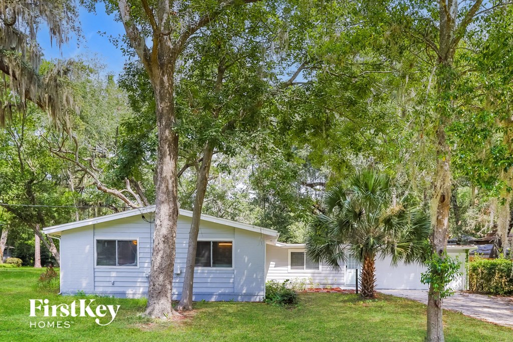 a small blue house with trees in front of it
