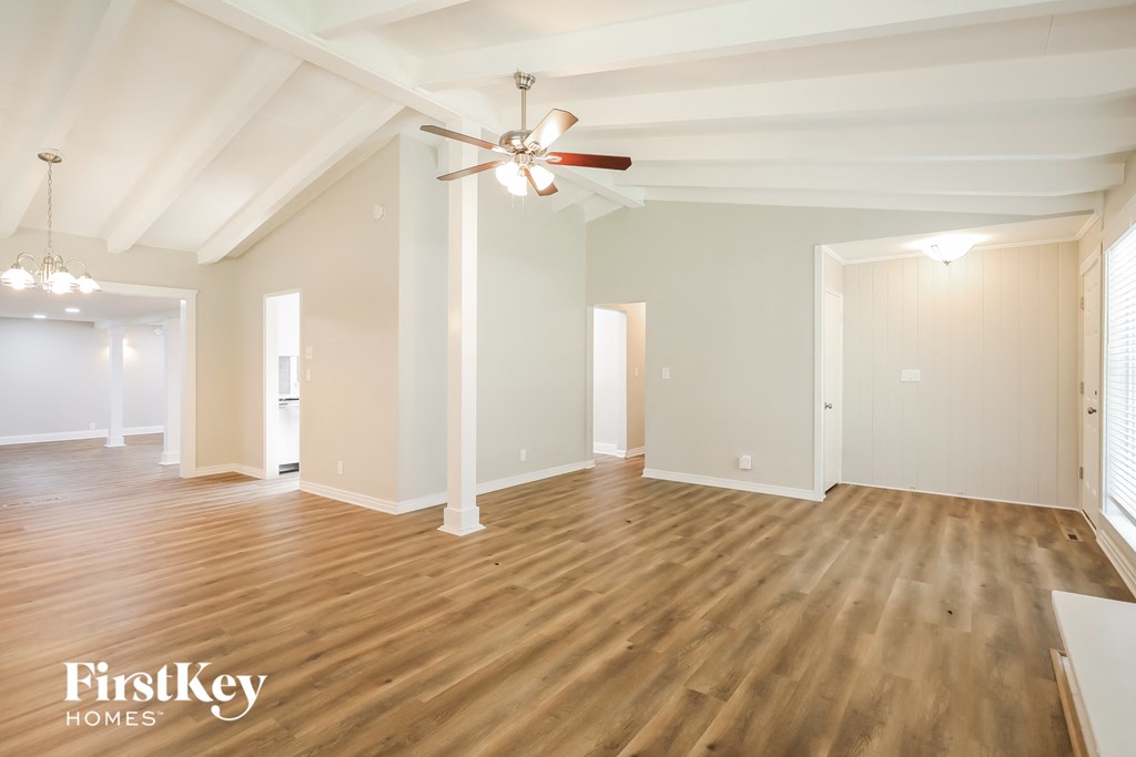 the living room and dining room with wood flooring and a ceiling fan