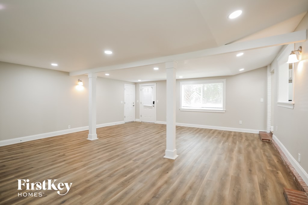 the living room with wood floors and white pillars