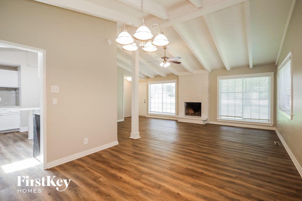 an empty living room with wood floors and a fireplace