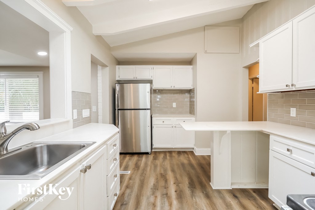 a kitchen with white cabinets and a stainless steel refrigerator