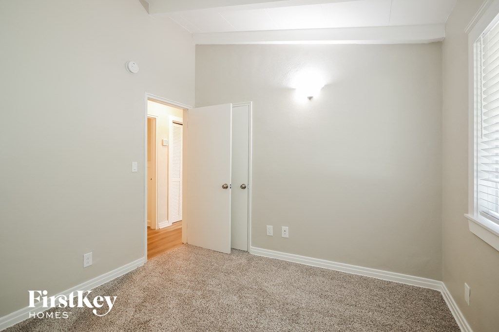 a bedroom with a carpeted floor and a door to a closet