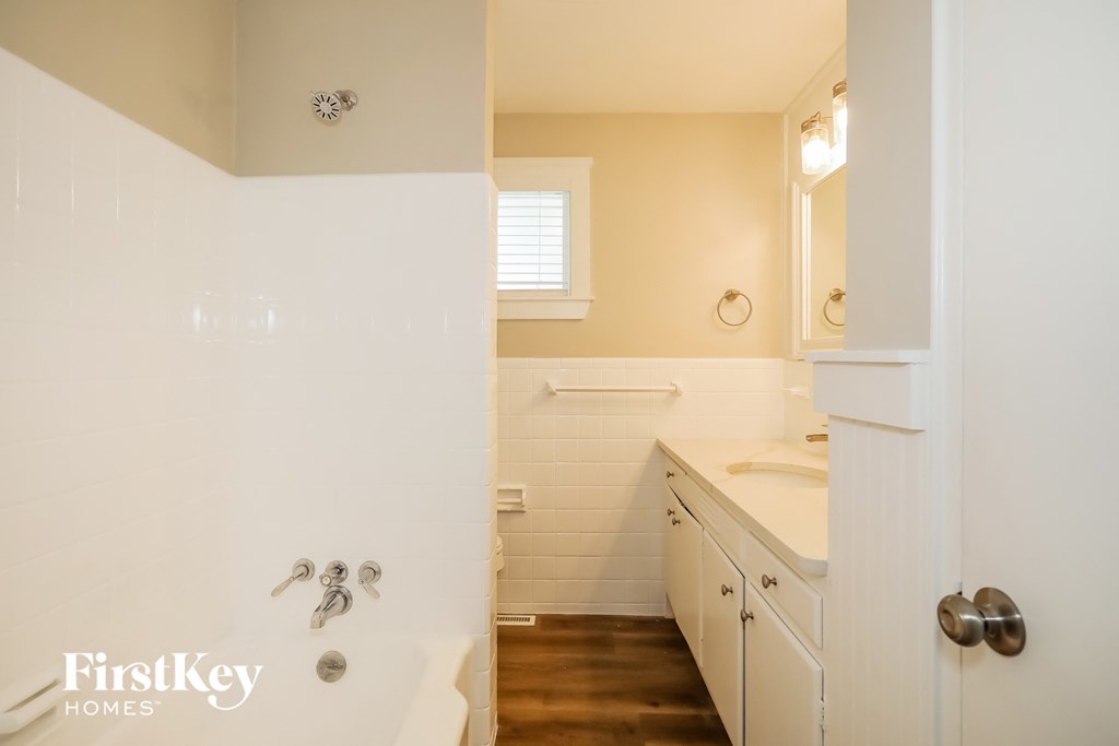 a bathroom with a tub and a sink and a mirror