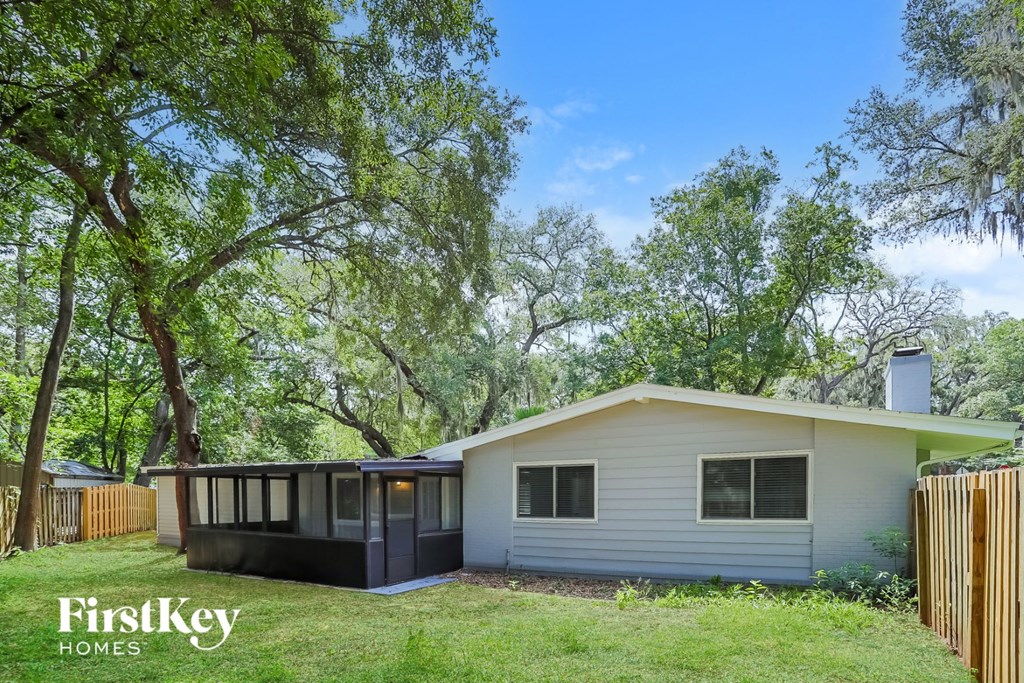 a small white house with a large tree in front of it