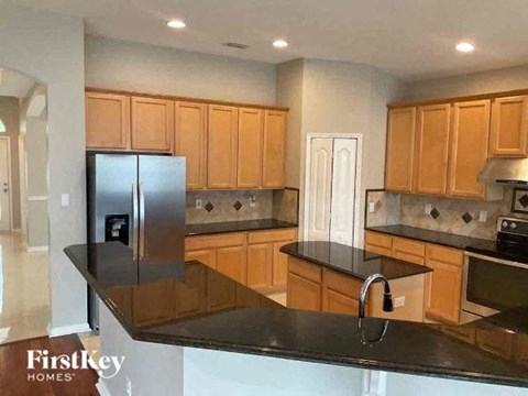 A kitchen with wooden cabinets and a black countertop.